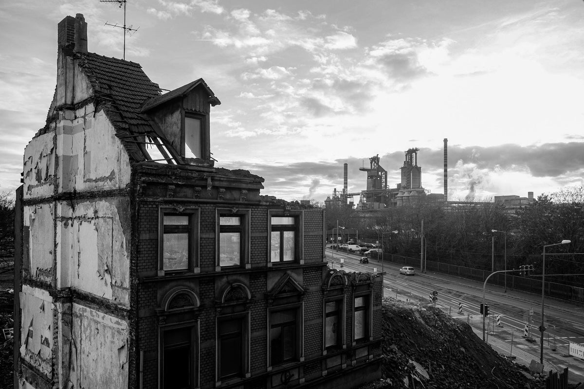 Ruiniertes Wohnhaus vor einer Industrieanlage – Industrial Cathedrals