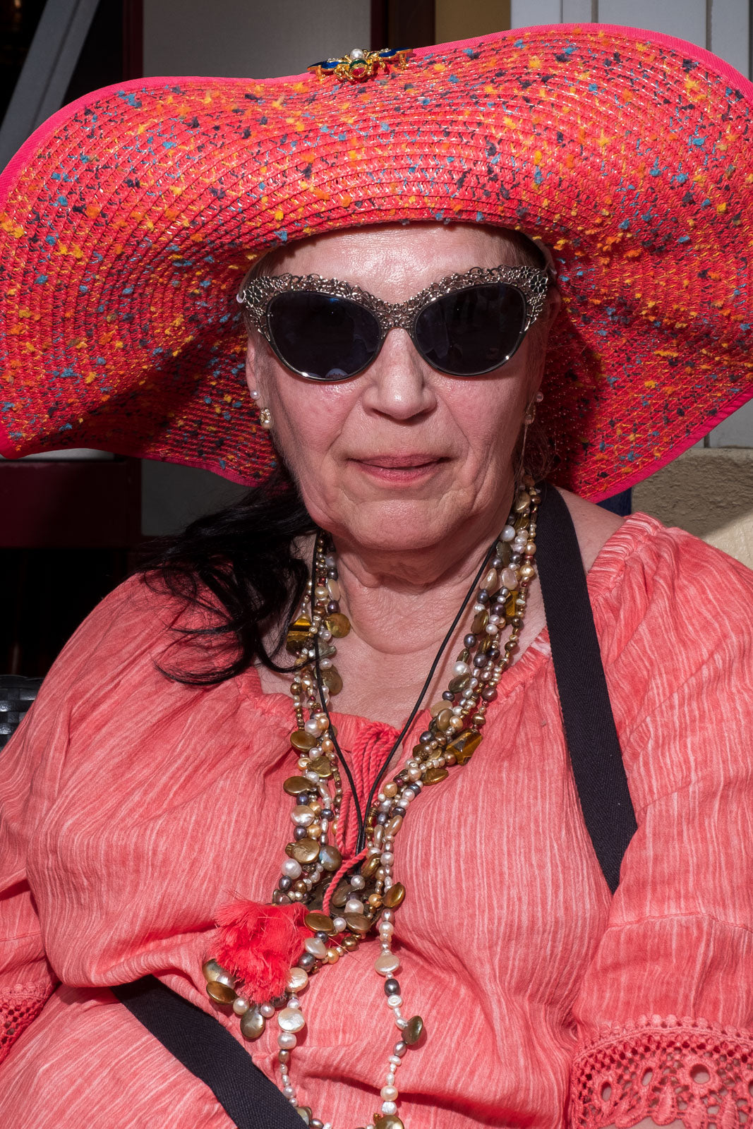 Street Portrait mit Blitz, eine ältere Dame mit rotem Hut und Sonnenbrille
